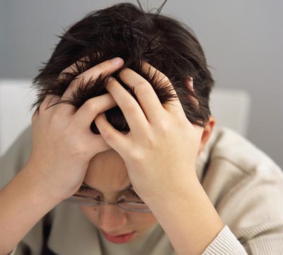 Stressed Schoolboy with Head in Hands